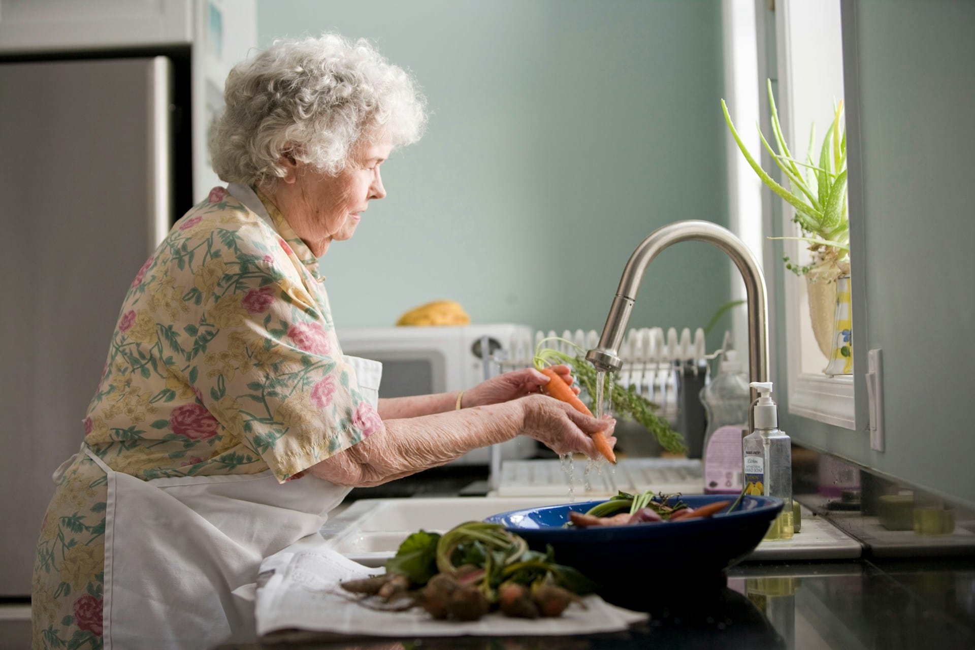 Woman using kitchen faucet