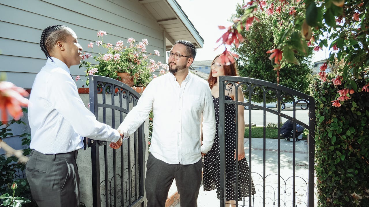 Men shaking hands next to garden gate