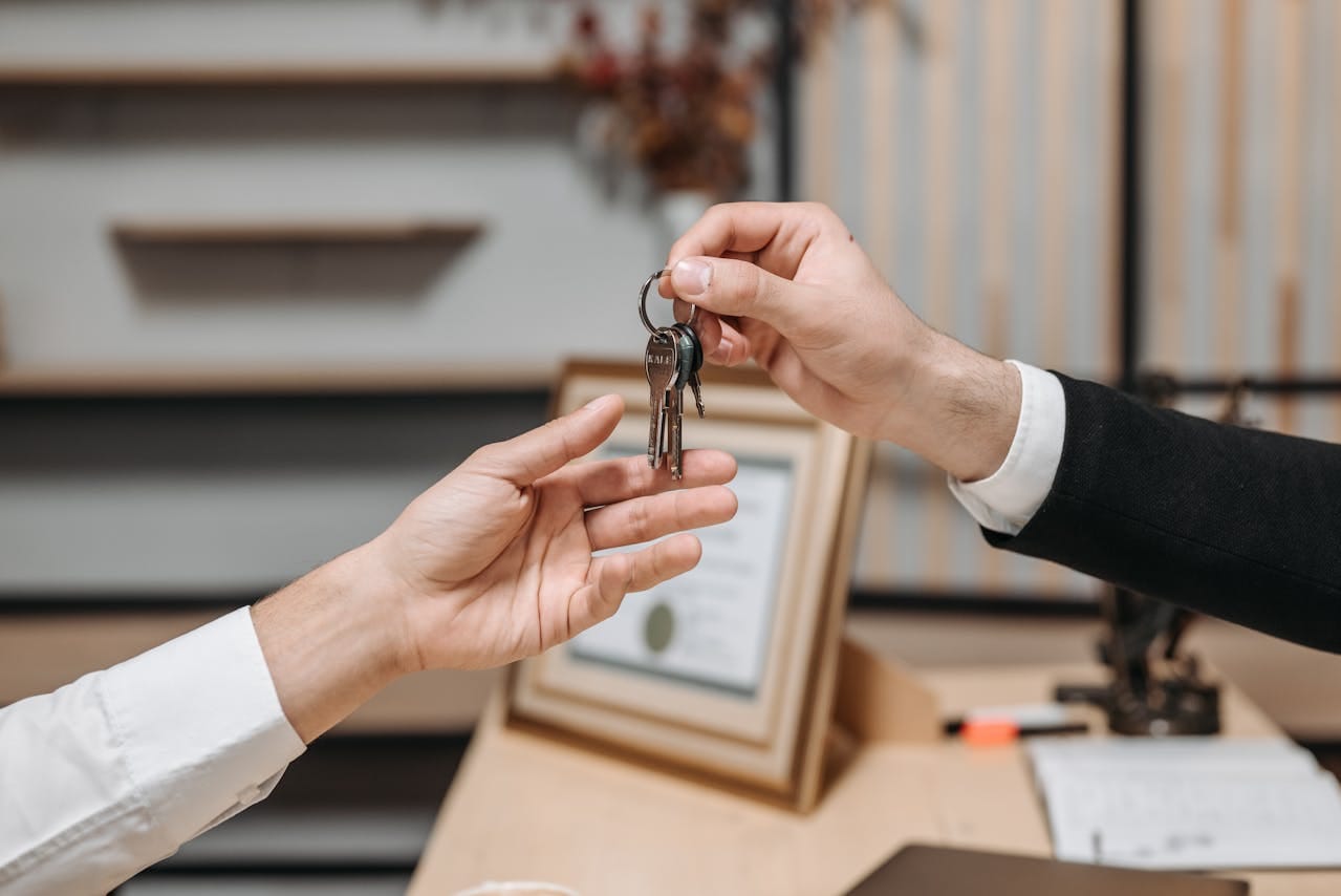 Keys being handed from one person to another